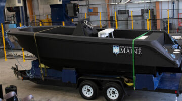 Photo of 3D printed boat on a trailer in the Advanced structures and composites building.