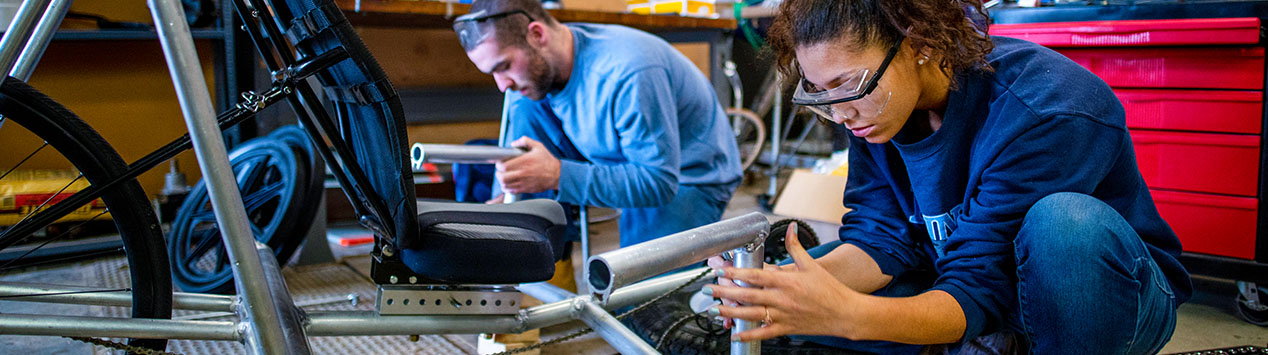 Two Mechanical Engineering Students working on a tube framed vehicle.
